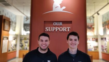 One employee is a cancer survivor. The other joined him on a trip back to the hospital for a health study.